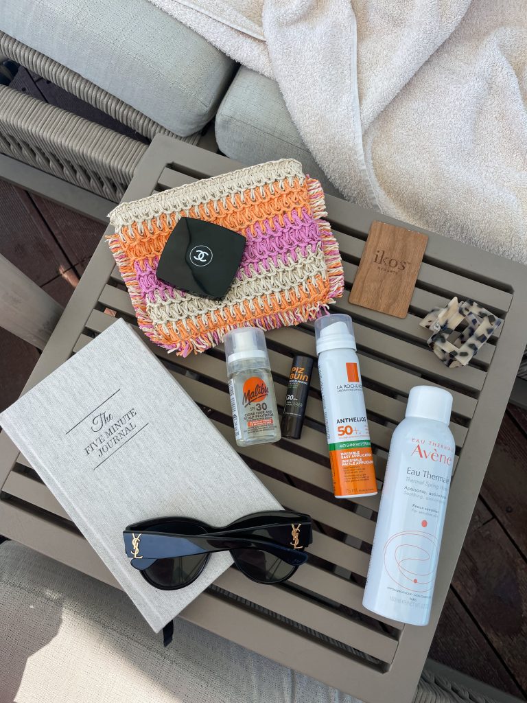 Lauren Elle Makeup Everything You Need to Know About Sunscreen SPF and sunglasses on table beside sun lounger